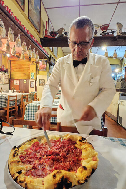 Pizzaiolo cortando pizza artesanal